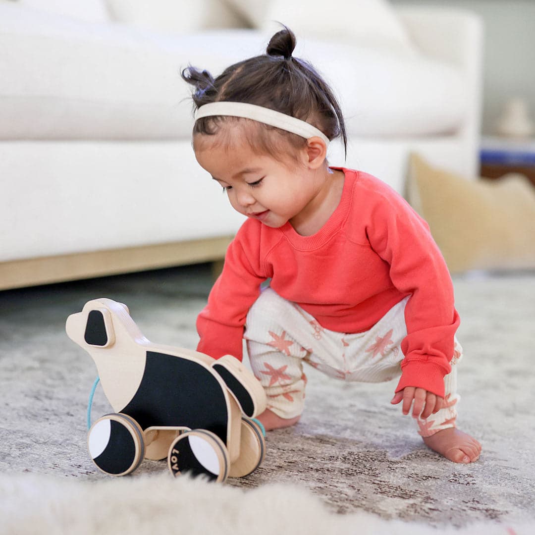 Child playing with The Pull Pup by Lovevery